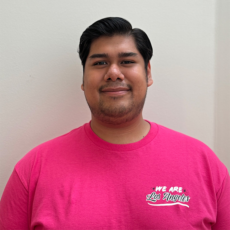 Headshot of a young man with short dark hair wearing a We Are Los Angeles shirt